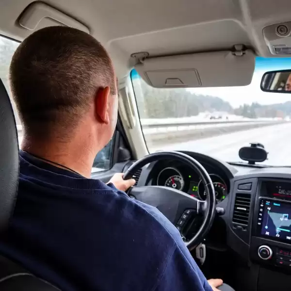 Driver behind the wheel of a moving vehicle