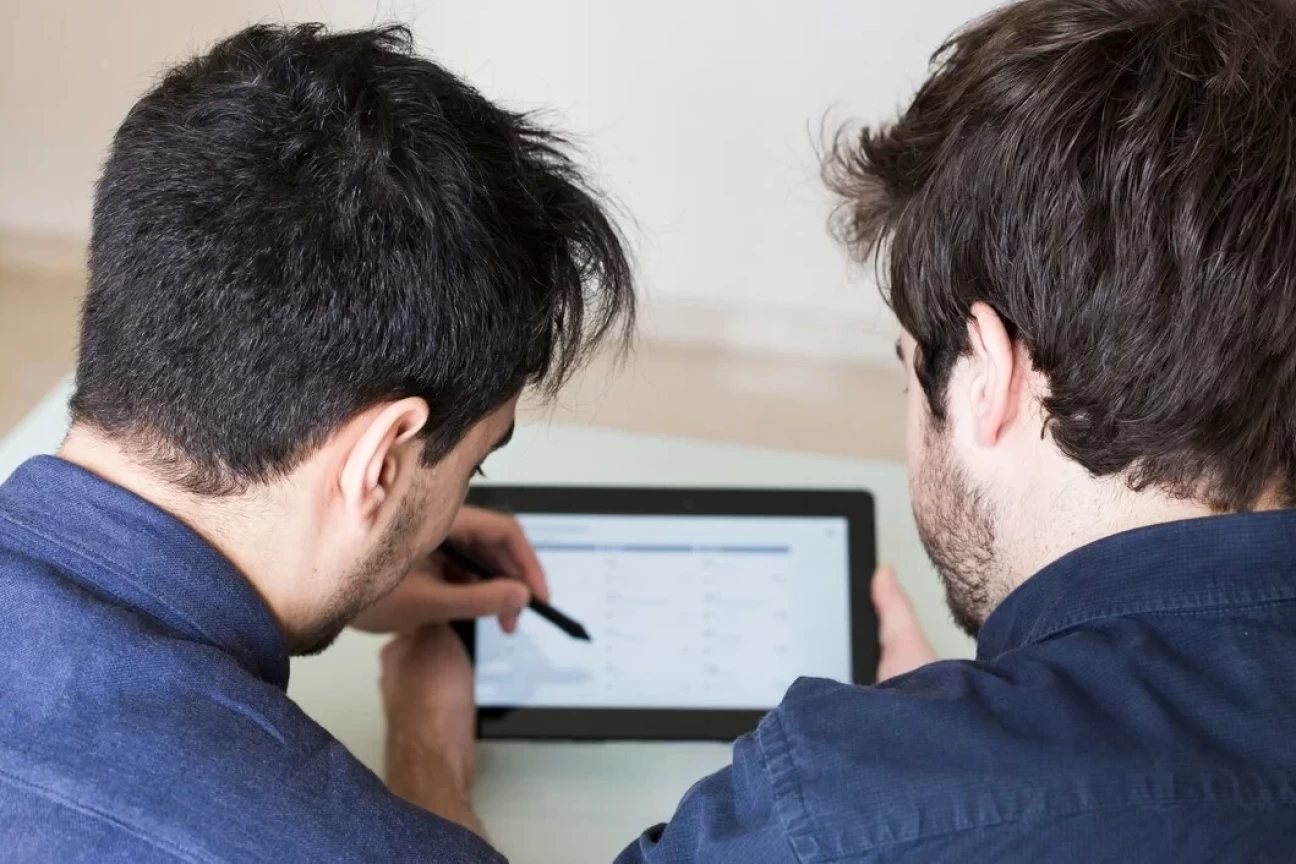 Two people reviewing a tablet