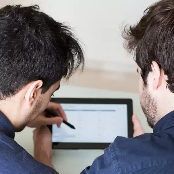 Two people reviewing a tablet